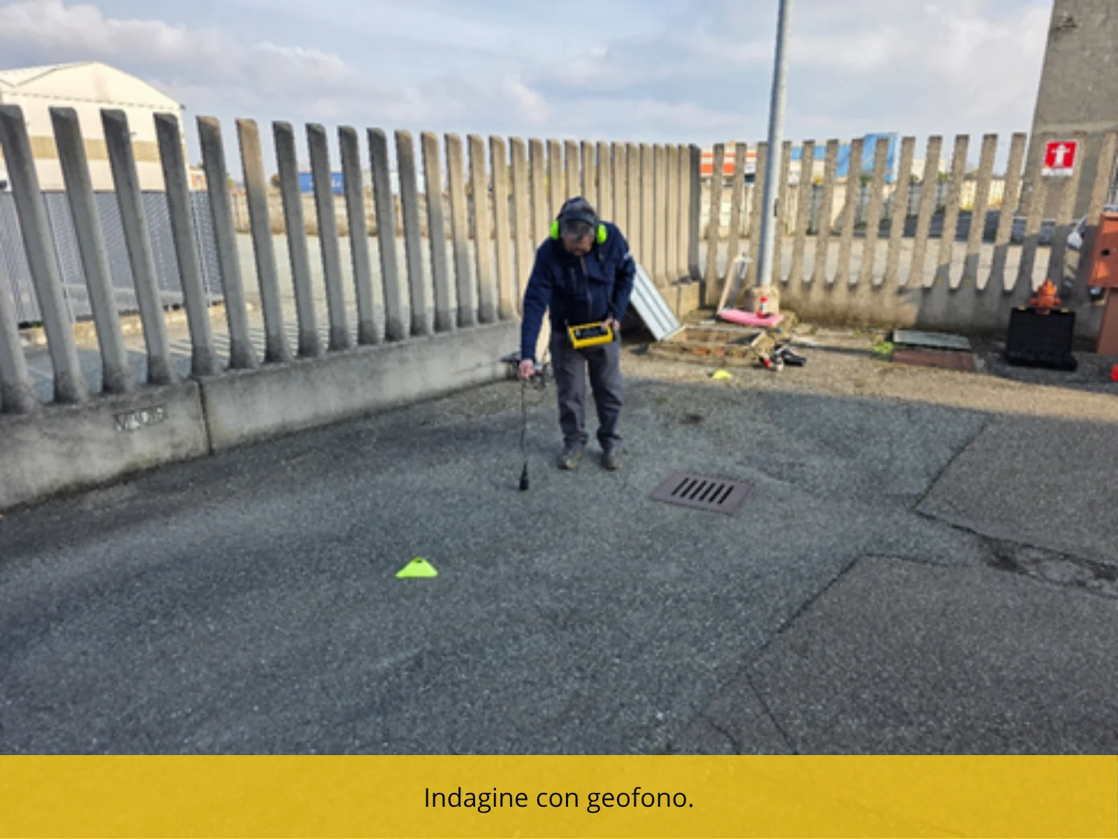 Tecnico che percorre una superficie esterna con il geofono, seguendo il tracciato di una tubazione interrata.