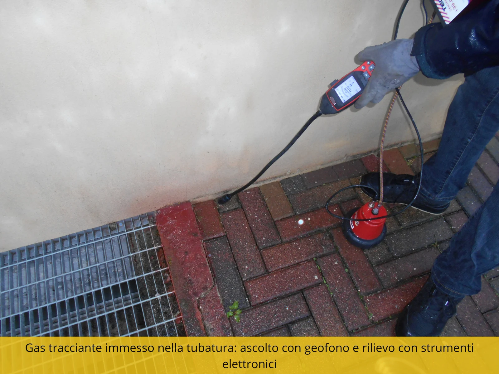 Sonda del gas tracciante inserita in una tubazione, con l'unità di rilevazione in mano al tecnico.