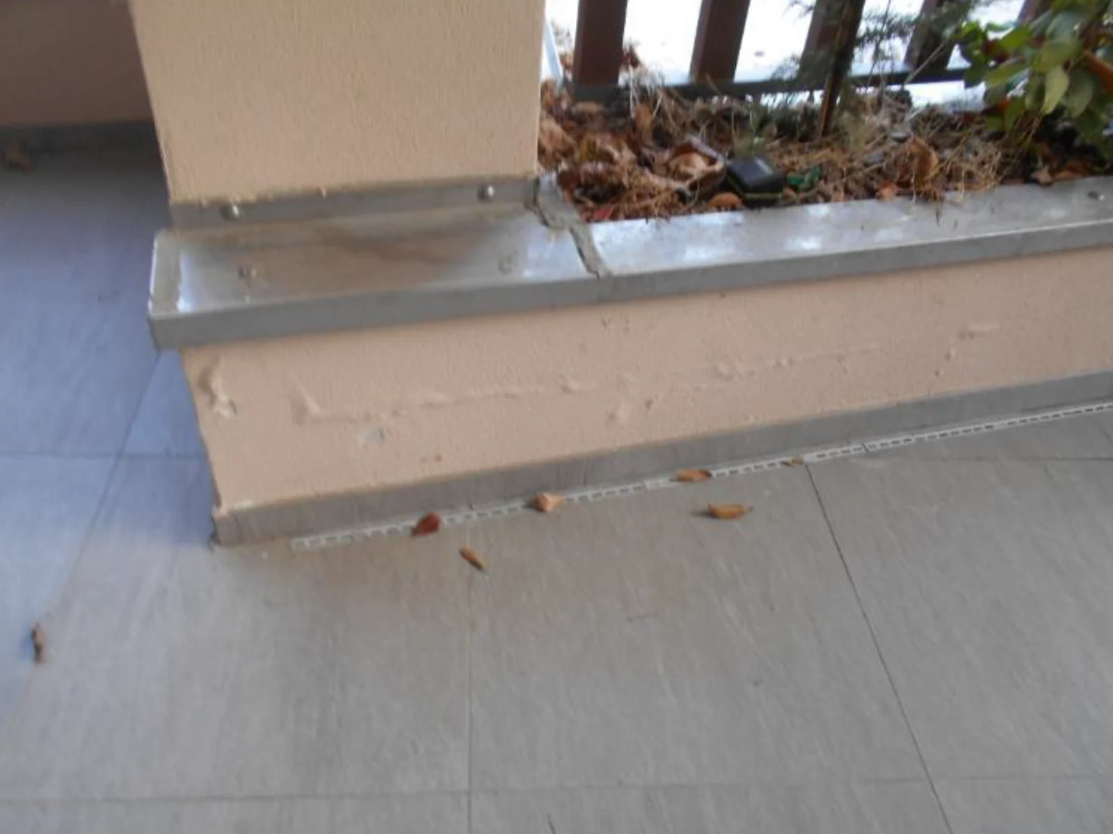 Soglia di una terrazza: la fioriera addossata al muro e il raccordo con la pavimentazione.