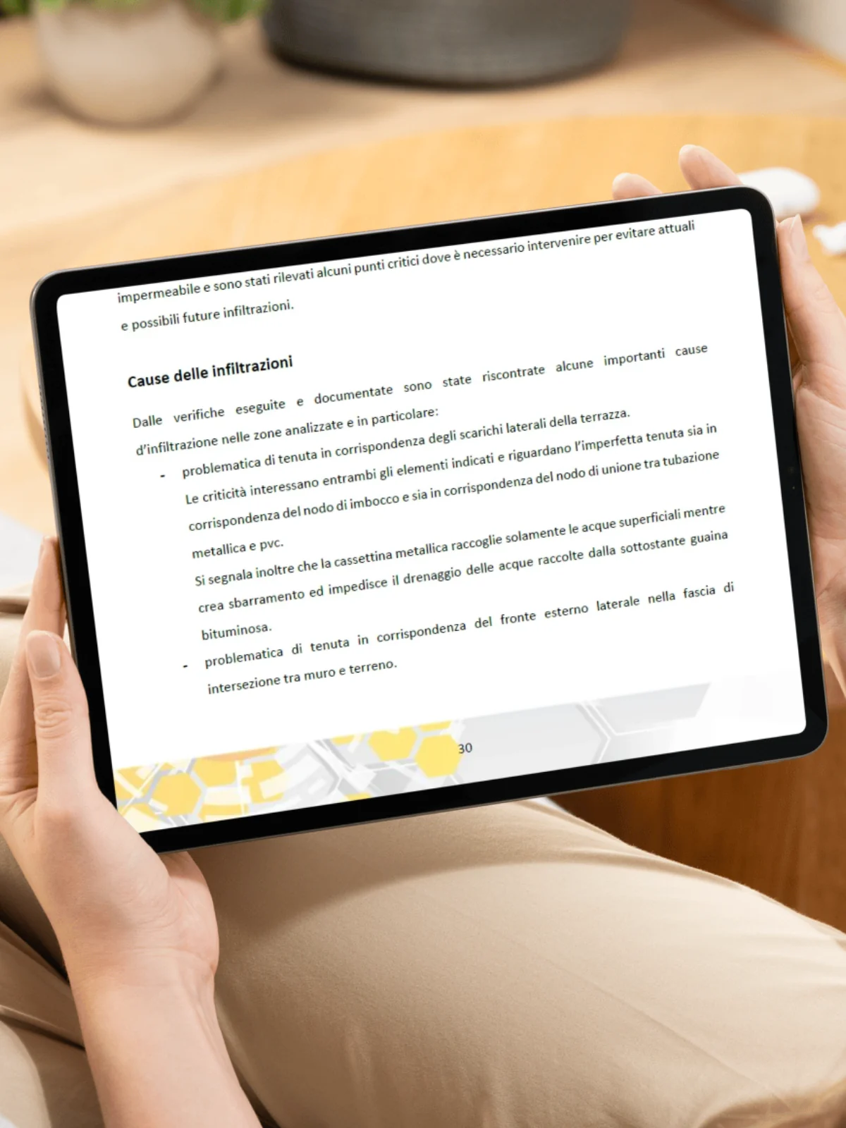 Una relazione aperta su un tablet, alla pagina che elenca le cause dell'infiltrazione riscontrate durante le verifiche.