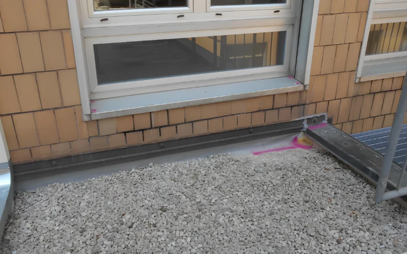 Terrazzo con finitura in ghiaia e serramento, in fase di verifica.