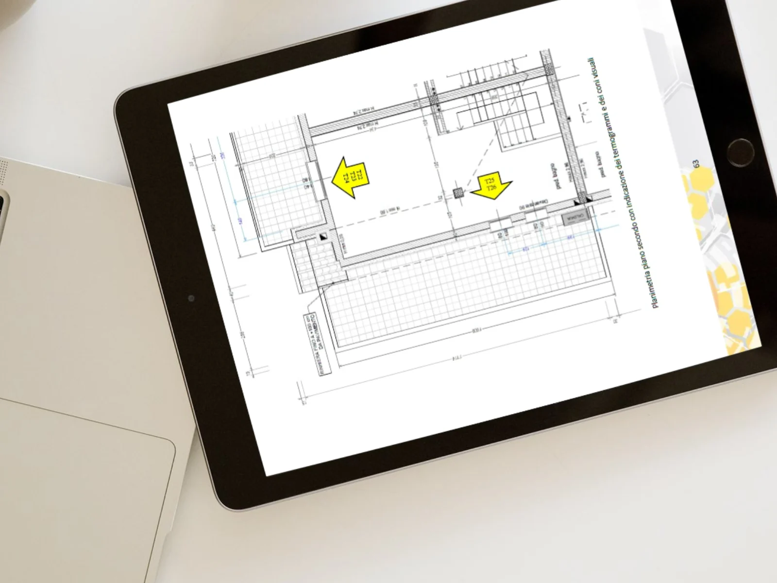 Pagina di relazione su tablet con la planimetria di un piano e due frecce gialle che indicano i punti in cui sono state eseguite le prove.