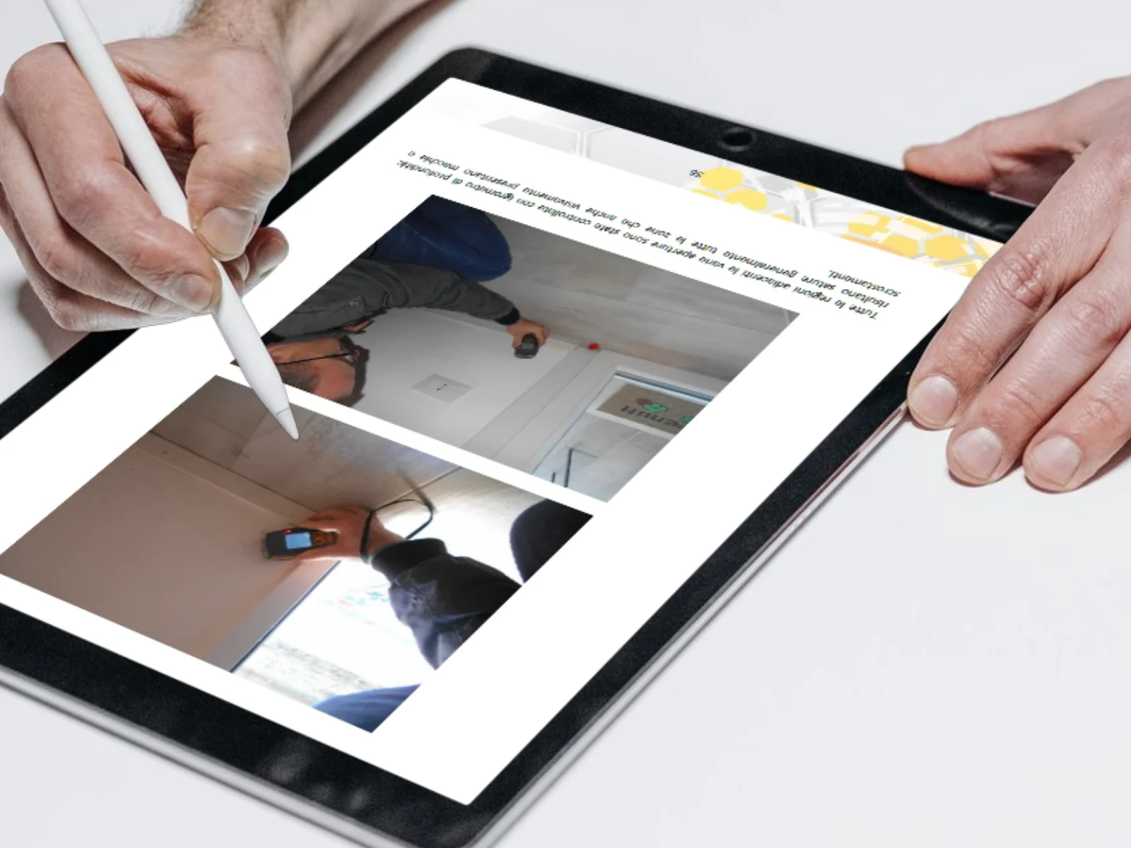 Una mano annota con la penna digitale una pagina di relazione aperta su tablet, con le fotografie dei rilievi in corso.