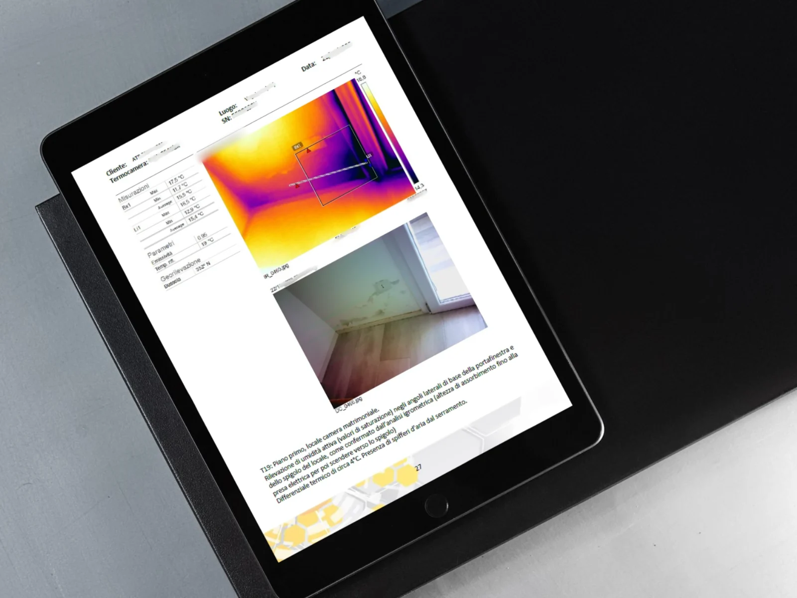 Pagina di una relazione aperta su un tablet: un termogramma con la tabella dei valori di temperatura, affiancato alla fotografia dello stesso angolo di stanza.